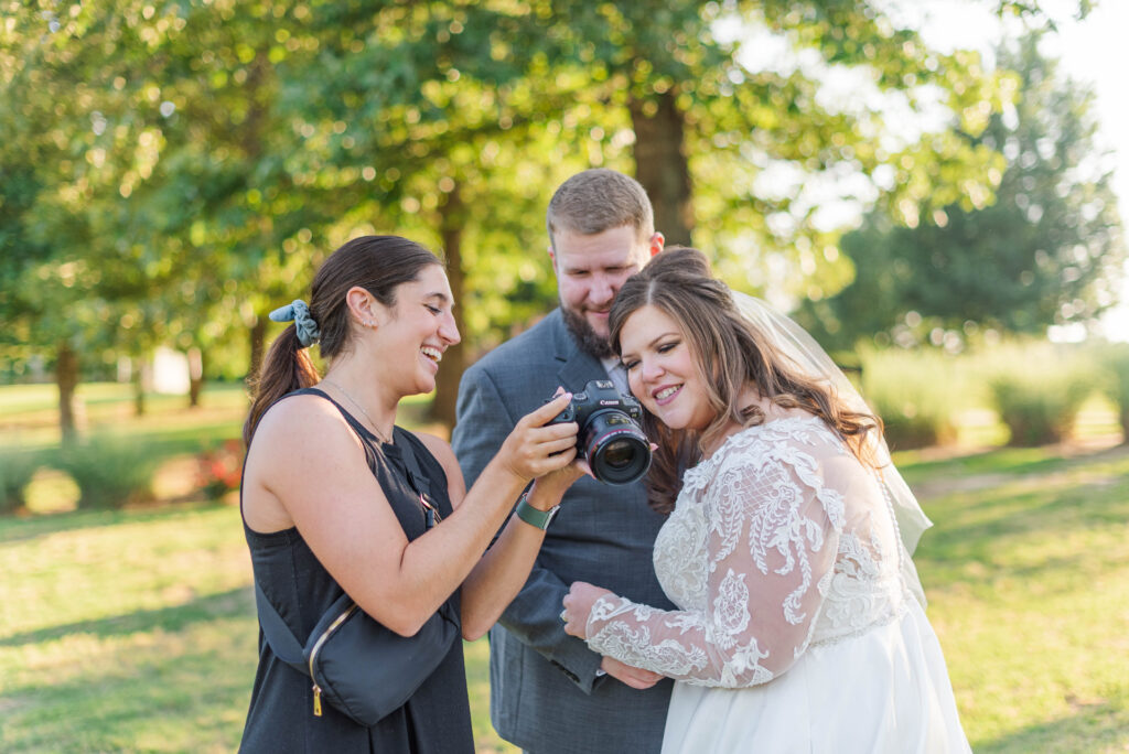 Wedding photographer showing a bride and groom an image on the back of her camera